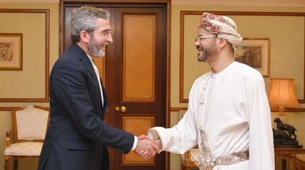 Iran’s Deputy Foreign Minister for Political Affairs Ali Bagheri Kani (L) shakes hands with Oman’s Foreign Minister Sayyid Badr Albusaidi in Muscat on March 12, 2023.